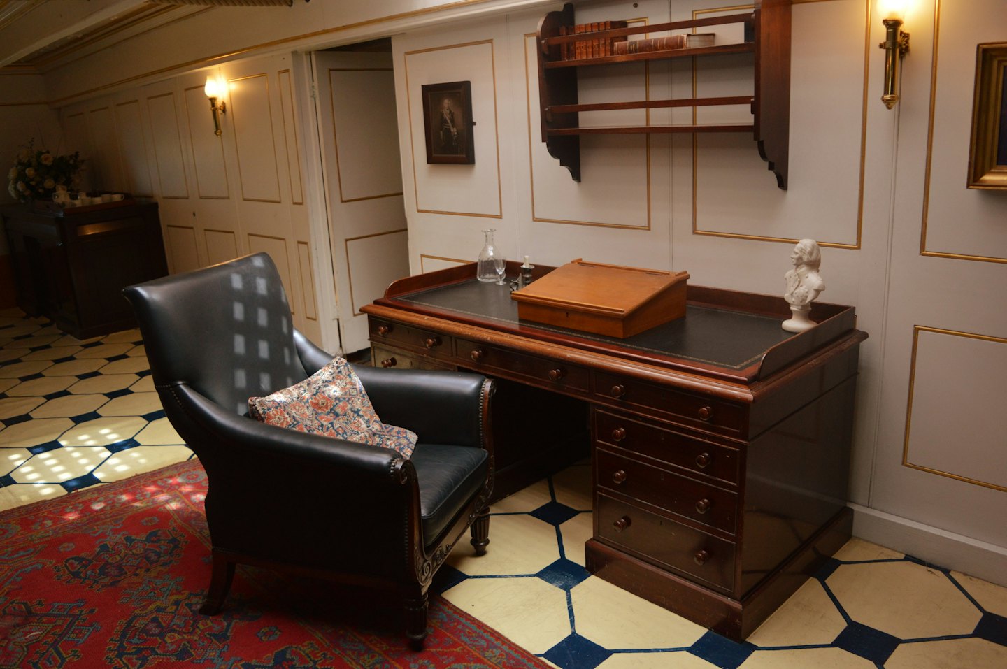 Classic study with leather chair, wooden desk, and bookshelves.